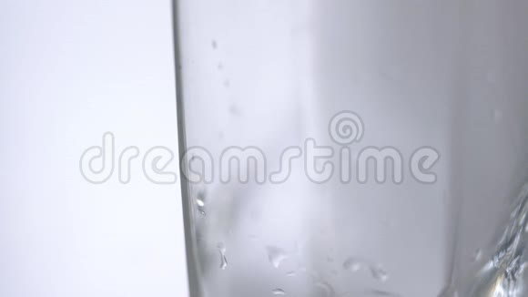 将新鲜矿泉水倒入桌子上的玻璃中白色背景带氧气球的新鲜起泡饮料视频的预览图