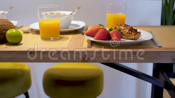 在家吃早餐新鲜草莓牛角面包和橙汁放在木桌上平静和放松的早晨视频的预览图