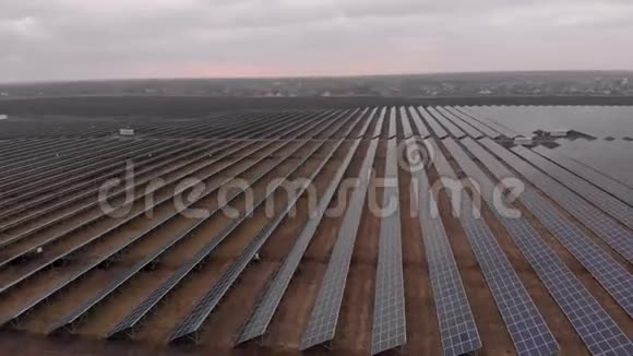 在多云的秋日无人机在太阳能农场观看大型太阳能电池板太阳能电池发电厂录像4K视频的预览图