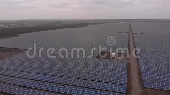 在多云的秋日无人机在太阳能农场观看大型太阳能电池板太阳能电池发电厂录像4K视频的预览图
