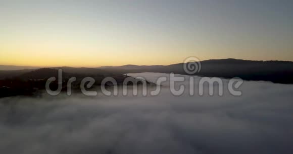 日出时雾蒙蒙的山谷弥漫着金色渐变的天空视频的预览图