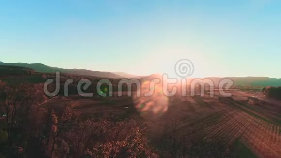 鸟瞰美丽的粉红色日落在昏暗的灯光下山的地平线和村庄在底部视频的预览图