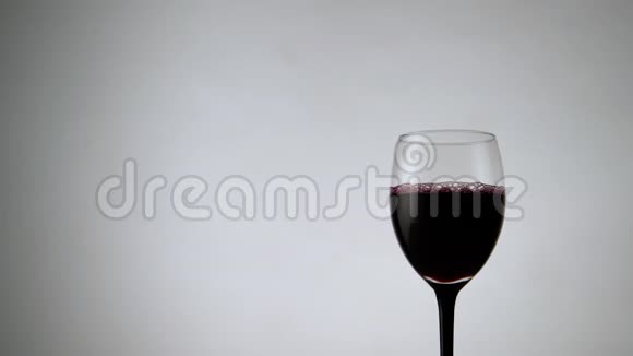 白色背景下红酒杯的全景在浅色背景下盛满酒精饮料的酒杯视频的预览图