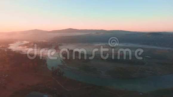 初秋时节美丽的雾蒙蒙的黎明笼罩着河流和山脉视频的预览图