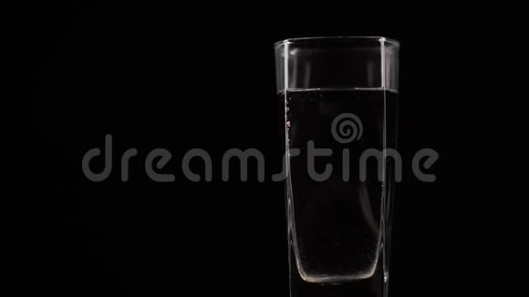 维生素C片溶解在一杯新鲜的矿泉水中在黑暗的背景下在装有氧气球的液体中泡泡丸视频的预览图