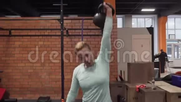 在健身馆做水壶运动的女人视频的预览图