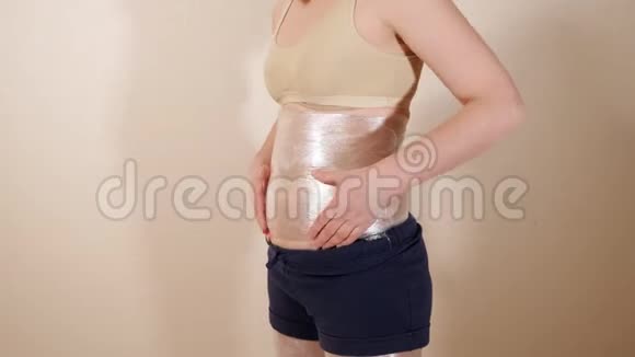 年轻女子用塑料包裹触诊胃部视频的预览图