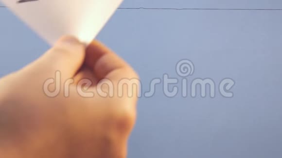 一个男人把一张白纸挂在蓝色背景上上面写着一个黑色的字视频的预览图