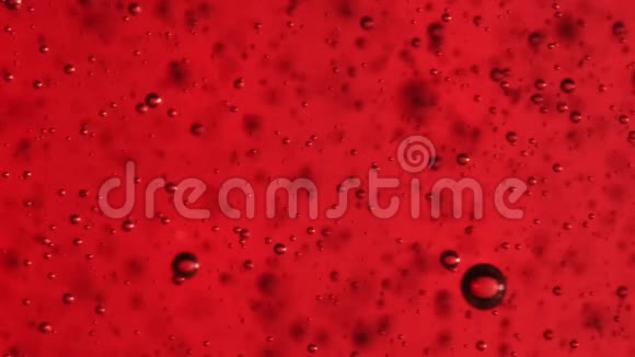 透明的气泡在红色背景的液体下上升视频的预览图