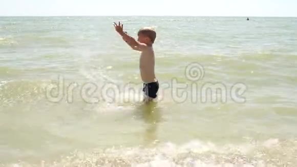 小快乐男孩在海里游泳泼水慢动作视频的预览图