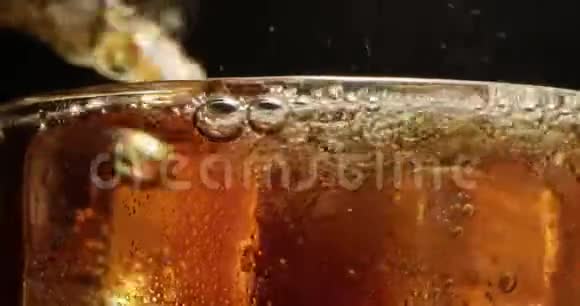 烈性苏打饮料与漂浮在冰杯上的气泡在黑色背景下的红色上的宏射视频的预览图