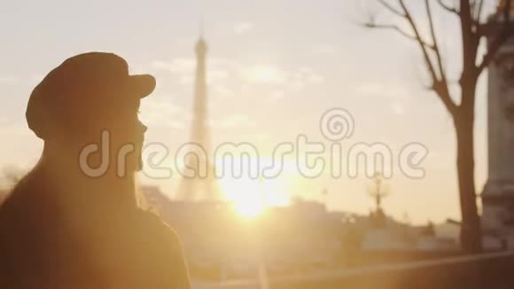 在巴黎慢动作中幸福的旅游妇女沿着埃菲尔铁塔的日落景色和粉红色的天空漫步的电影后视镜视频的预览图