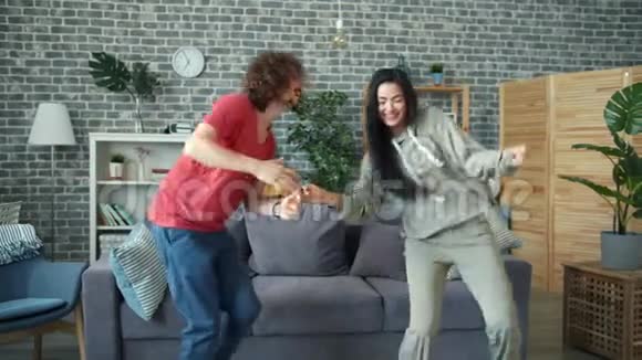 可爱的混血情侣在家跳舞享受快乐时光视频的预览图