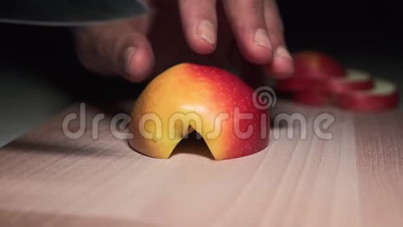 特写切片苹果一个男人在厨房的砧板上切红苹果视频的预览图