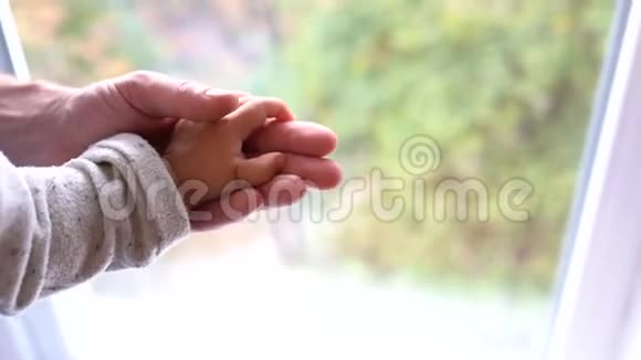 宝贝爸爸和他们的手在家的窗户附近视频的预览图