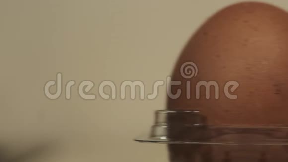 棕色鸡蛋在一个透明的塑料盒子上的厨房桌子特写滑动运动视频的预览图