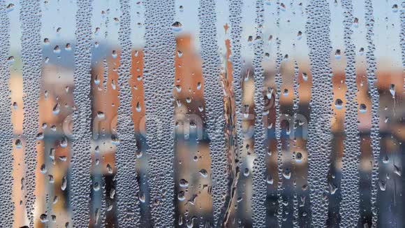 扭曲的窗户玻璃水滴落下来模糊的城市在背景视频的预览图
