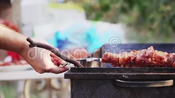 把烤肉串放在烤架上烧烤烹饪肉和火的烟雾野餐特写镜头慢镜头视频的预览图