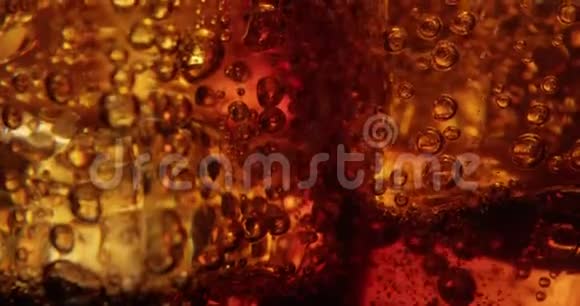 杯中的可乐气泡和冰块在红色上喷射视频的预览图