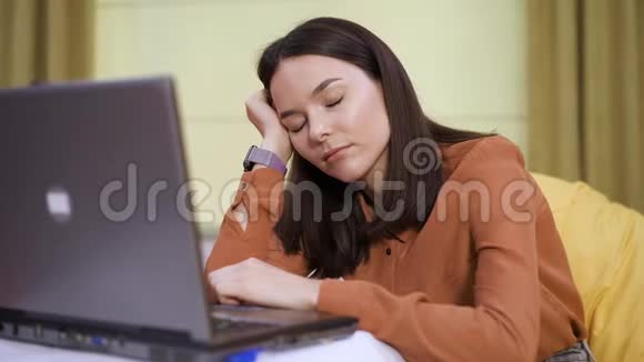 疲惫的女人睡在办公室特写的笔记本电脑附近视频的预览图