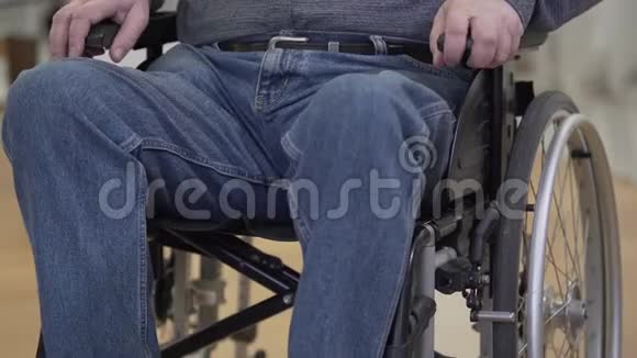 无法辨认的白人老人试图从轮椅上站起来极度残疾双腿瘫痪的男性退休人员视频的预览图