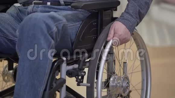 男性成熟白种人轮椅手滚轮的特写无法辨认的残疾人离开左边视频的预览图