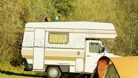 年轻女孩在山野复古露营车上放松视频的预览图