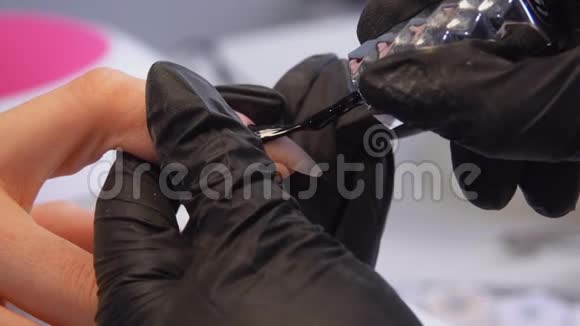 医生双手戴黑色手套用黑色凝胶涂指甲视频的预览图