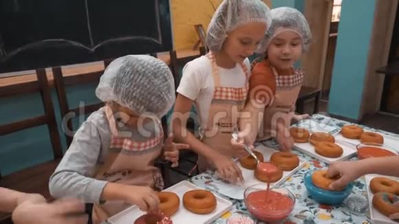 孩子们在烹饪学校准备烹饪大师班的甜甜圈孩子们一起在面包学校做甜甜圈视频的预览图