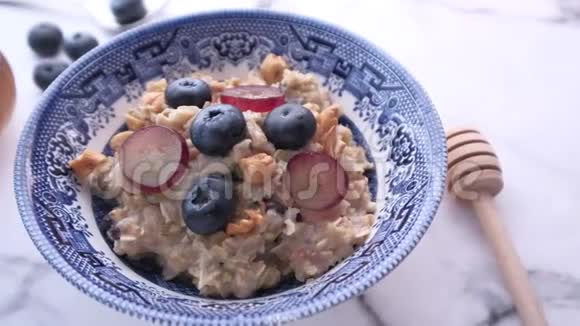 在碗里放燕麦餐上的浆果关门视频的预览图
