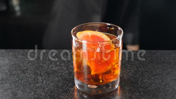 鸡尾酒制作概念冰在缓慢的运动中被滴入玻璃中180fps特写孤立的黑色视频的预览图