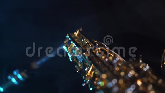 金色闪亮的阿尔托萨克斯管黑色背景与蓝色烟雾视频的预览图