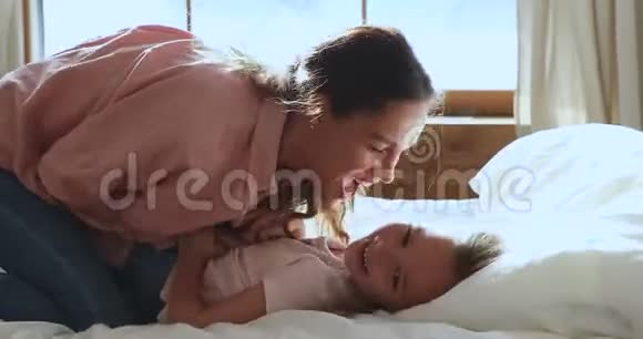 玩妈妈挠痒小孩女儿笑玩躺在床上视频的预览图