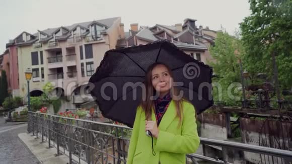 雨天漂亮的女人正站在桥上的一把黑伞下肖像视频的预览图
