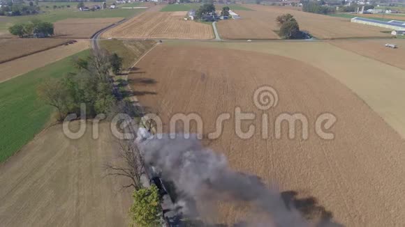 从头顶看蒸汽火车吹烟和蒸汽沿着乡村行驶视频的预览图