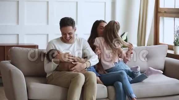 有趣的幸福家庭在沙发上玩痒慢动作视频的预览图