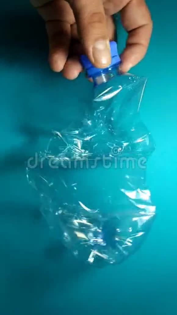 将塑料瓶从水中揉碎在蓝色背景下处置理念是循环利用生态环保视频的预览图