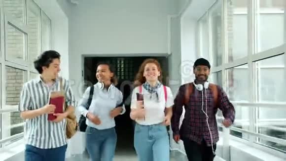 快乐的朋友们在学校走廊里跑步做着击掌的笑声视频的预览图
