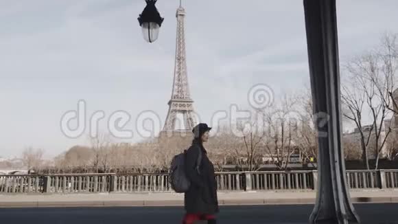 影院侧景拍摄优雅幸福的美女沿着巴黎街头漫步阳光明媚的埃菲尔铁塔观景慢动作视频的预览图