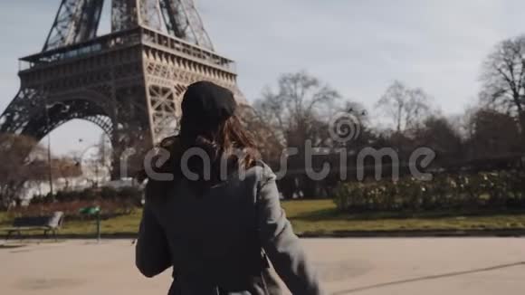 镜头跟随美丽兴奋的旅游妇女跑到巴黎埃菲尔铁塔微笑着回到镜头慢动作视频的预览图