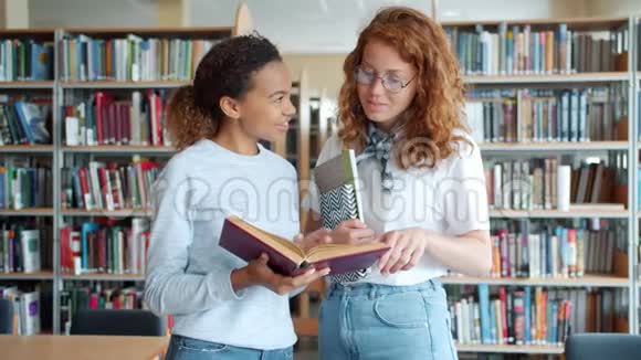 快乐的女生在图书馆聊天讨论书中的笑视频的预览图