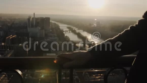 巴黎埃菲尔铁塔观景台围栏上的男子手滑近景夕阳西下天空全景慢镜头视频的预览图