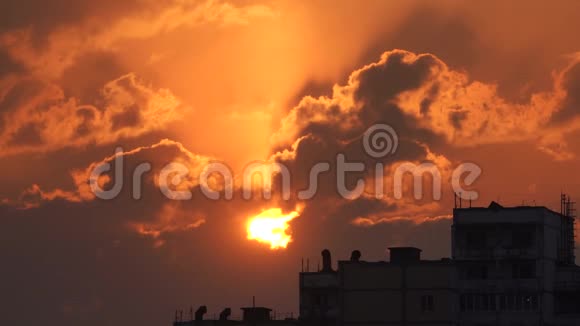 城市轮廓与戏剧性的日落橙色云和太阳盘视频的预览图