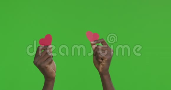 一双黑色的雄性手在红纸心上跳舞视频的预览图