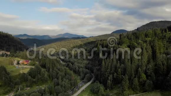 在多云的天空下山上绿色森林的景象视频的预览图