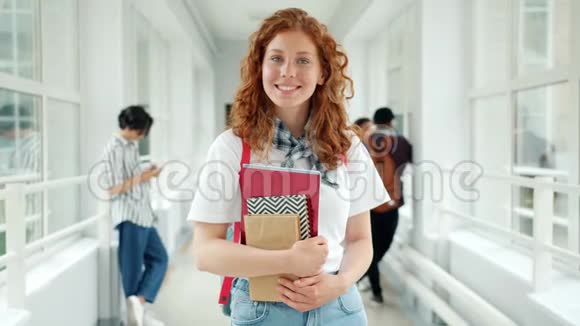 红头发的女学生站在学校大厅里脸上带着微笑视频的预览图