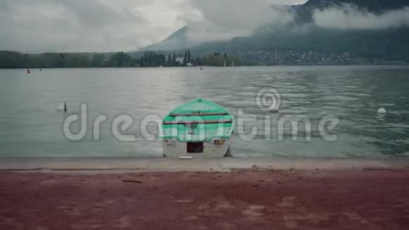 穿着薄荷雨衣的人走近停泊在湖岸附近的一艘船开始停泊它视频的预览图