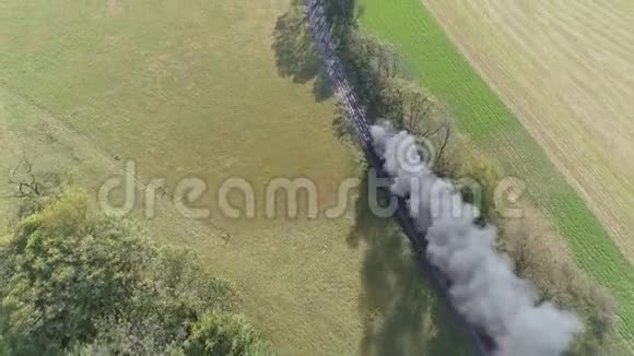 一台老式的蒸汽机经过农田吹烟和蒸汽的空中景色视频的预览图