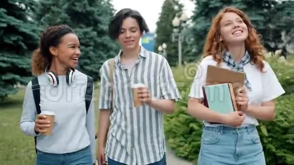 一群青少年带着书和咖啡在户外散步打手势视频的预览图