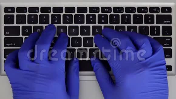 男性手打字在带有橡胶手套的笔记本电脑键盘上视频的预览图
